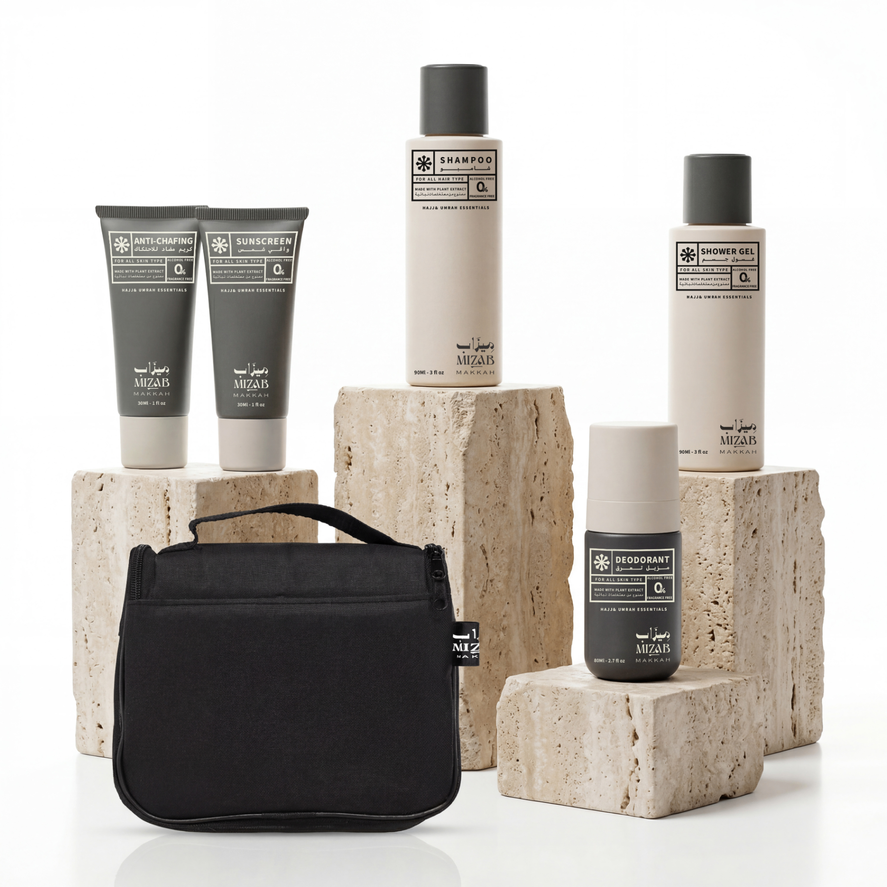Mizab personal care products — shampoo, shower gel, deodorant, sunscreen, anti-chafing cream, and a travel bag arranged on travertine blocks