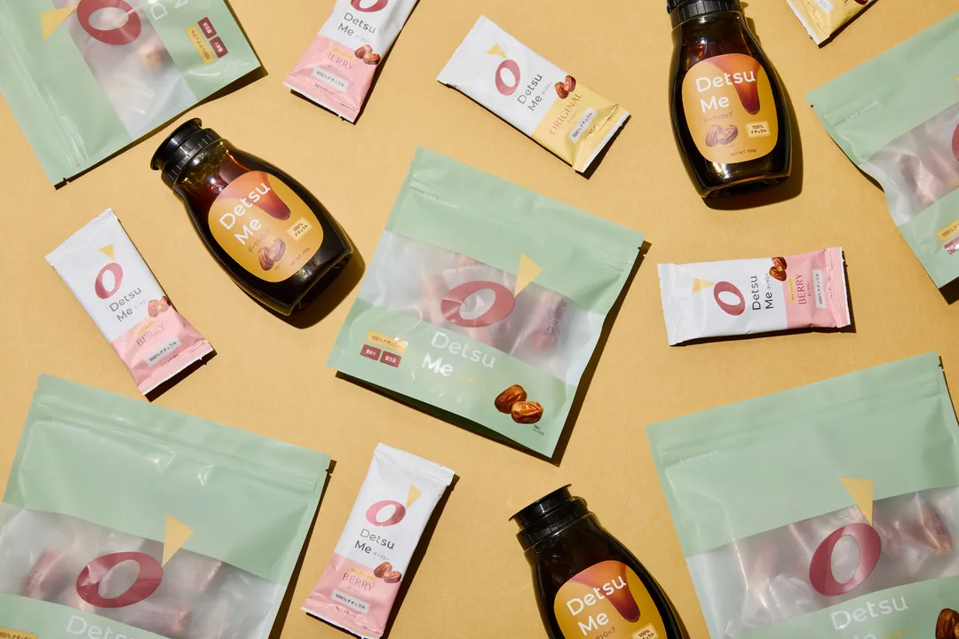 Detsu Me dates syrup, snack bars, and pouches arranged on a warm surface